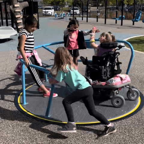an inclusive playground spinner with kids of all abilities playing