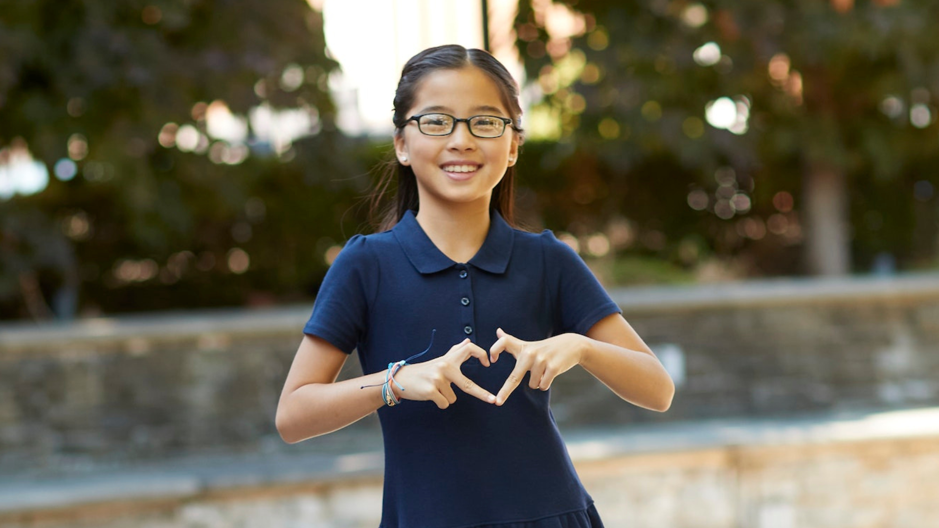 A girl holding her hands in the shape of a heart