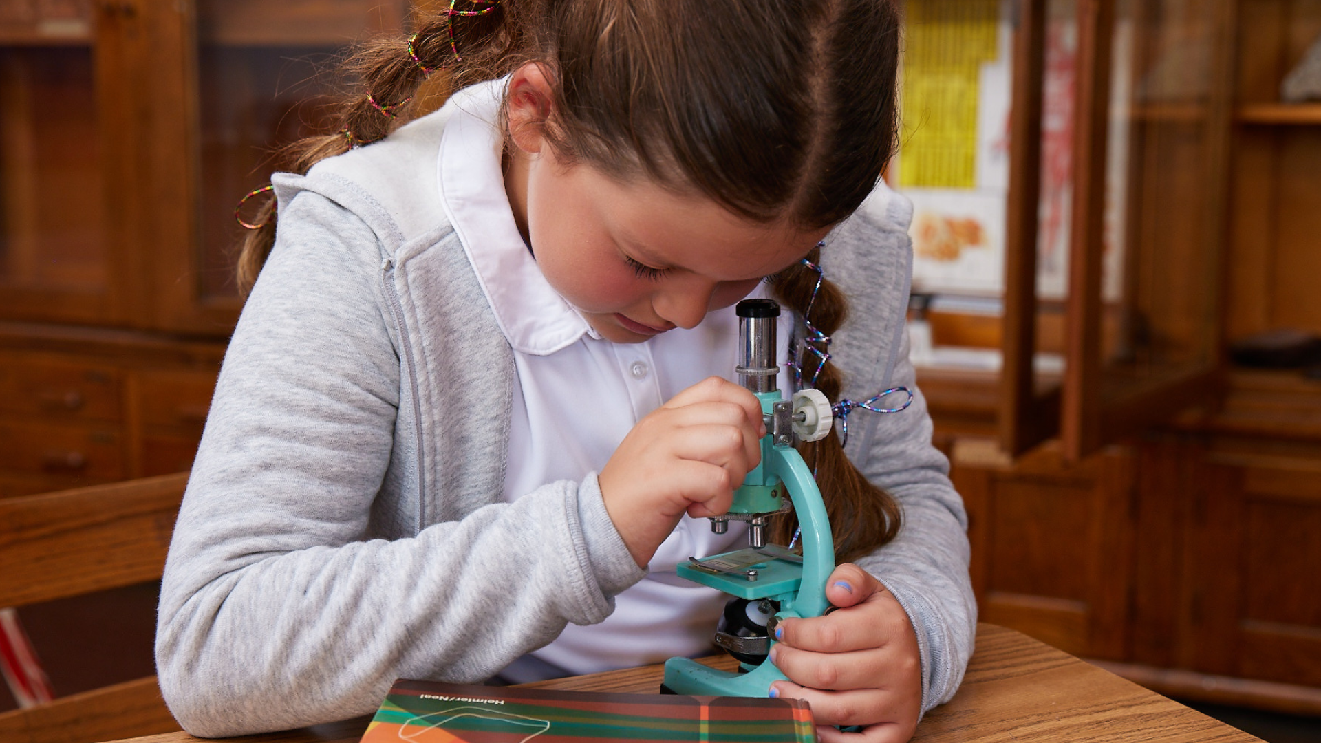 a young girl looking into a microscope